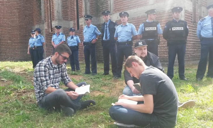 Studentët lexojnë para kishës në kampusin universitar